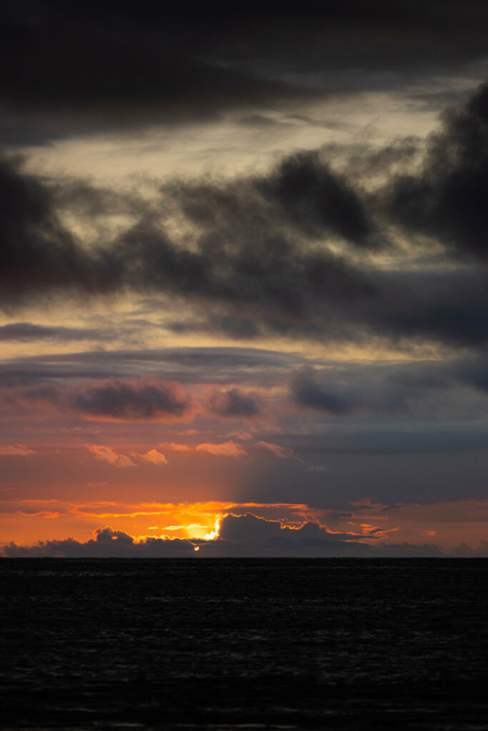 Dramatic sunset wallpaper with dark textured clouds and vibrant orange gold sky background