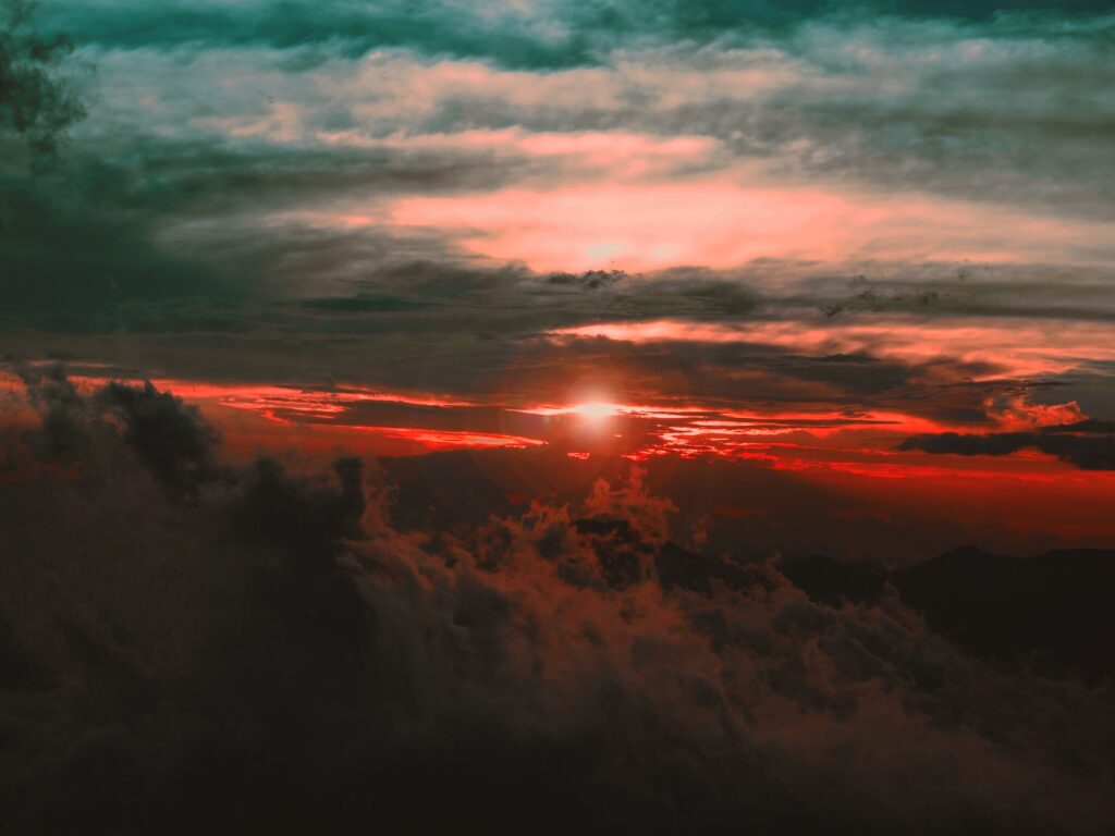 Dramatic sunset wallpaper with vibrant red and orange clouds creating a moody sky background