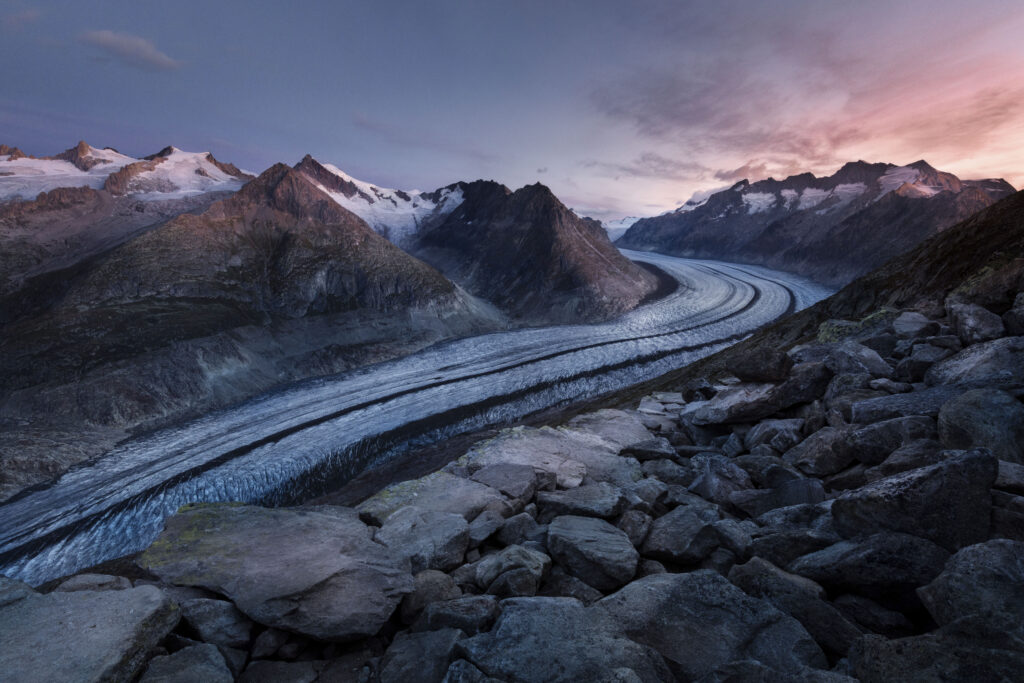 Dramatic mountain landscape with rugged peaks twilight sky winding glacier deep valley wallpaper background