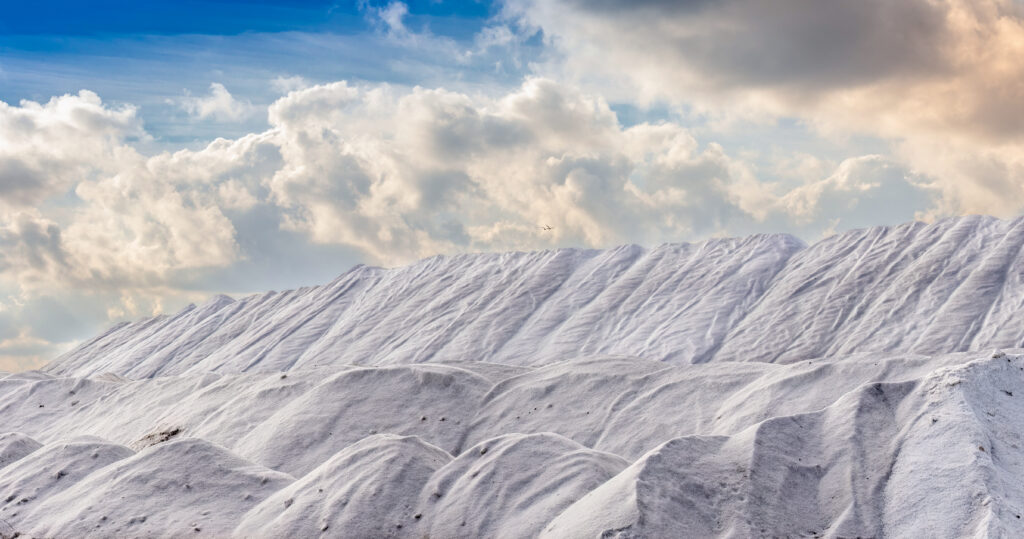 White sand hills with textured relief under soft clouds creating a dramatic landscape wallpaper