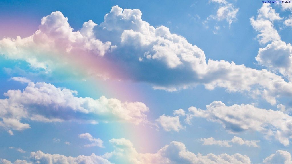 Aesthetic cloud wallpaper with fluffy white clouds and ethereal rainbow on vibrant blue sky