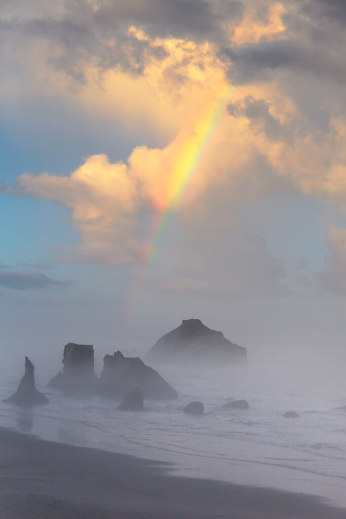 Serene seascape with rugged rocks misty waves vivid rainbow dramatic clouds tranquil coastal wallpaper