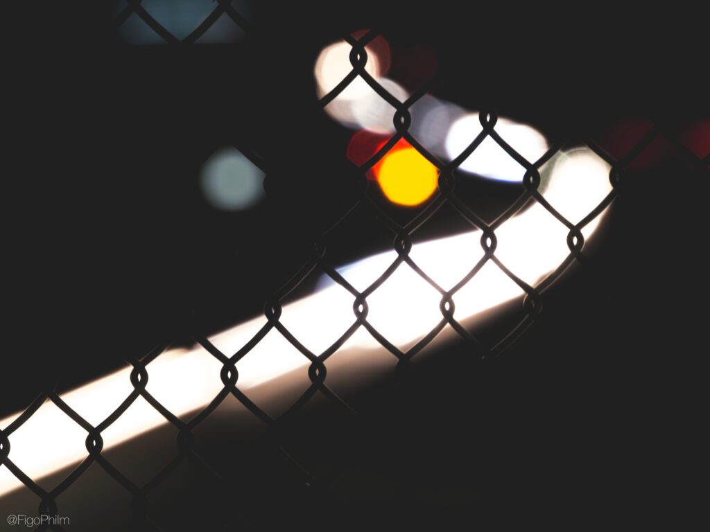 Dreamy Chain-Link Fence Wallpaper with Blurred Lights Background