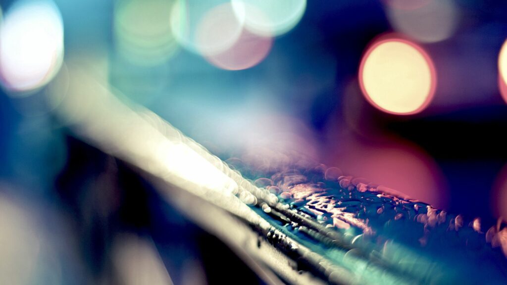 Dreamy Rain-Soaked Railing with Blurred Lights Wallpaper Background