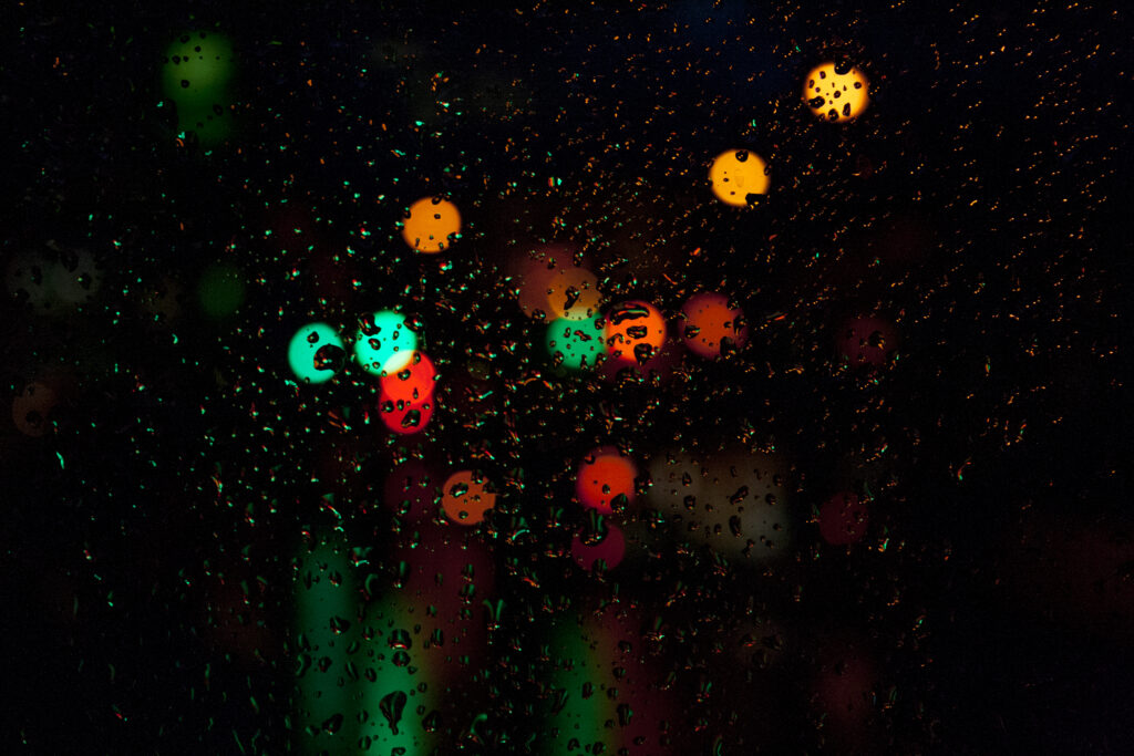 Dreamy Raindrops on Glass: Colorful Night-Time Wallpaper Background