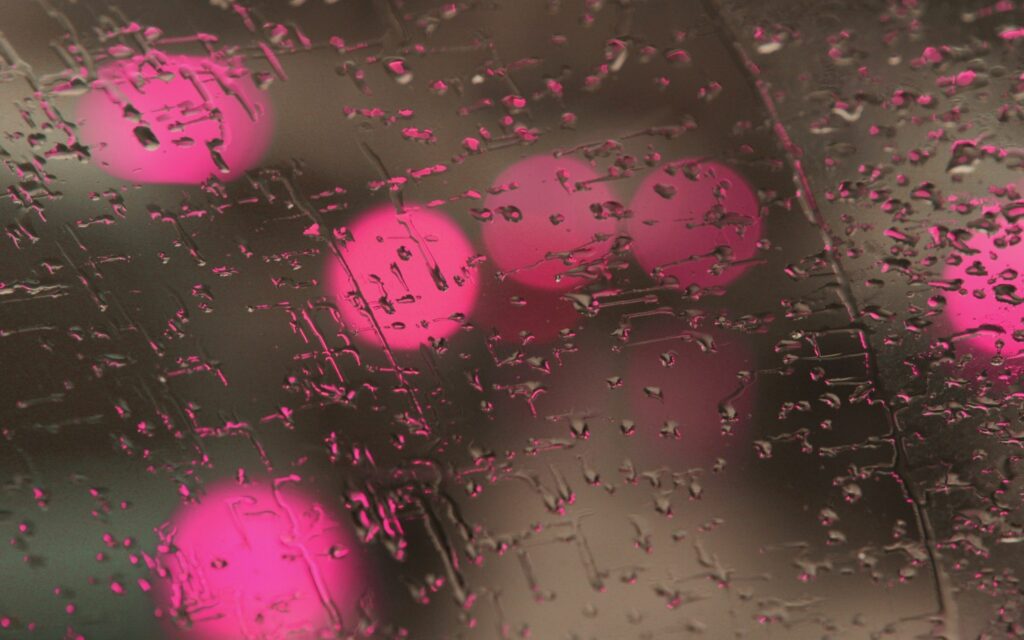 Dreamy Water Droplet Wallpaper: Vibrant Glass Surface with Pink & Red Lights