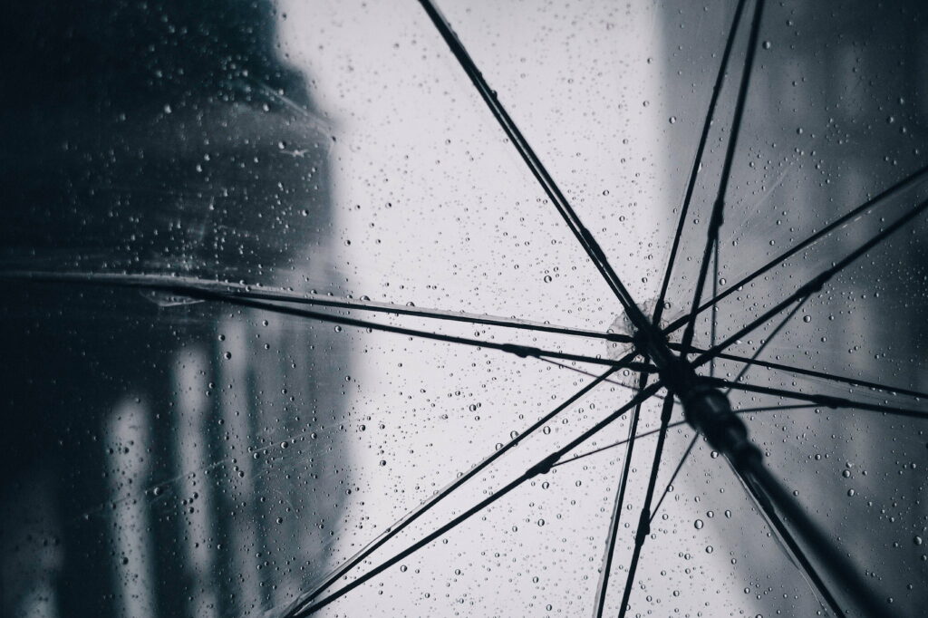 Dancing Raindrop Symphony: A captivating wallpaper with wet transparent umbrella as a soothing background image