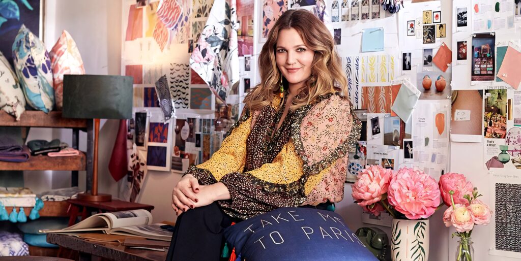 Drew Barrymore in vibrant art studio with colorful patterns floral designs and cozy textures wallpaper