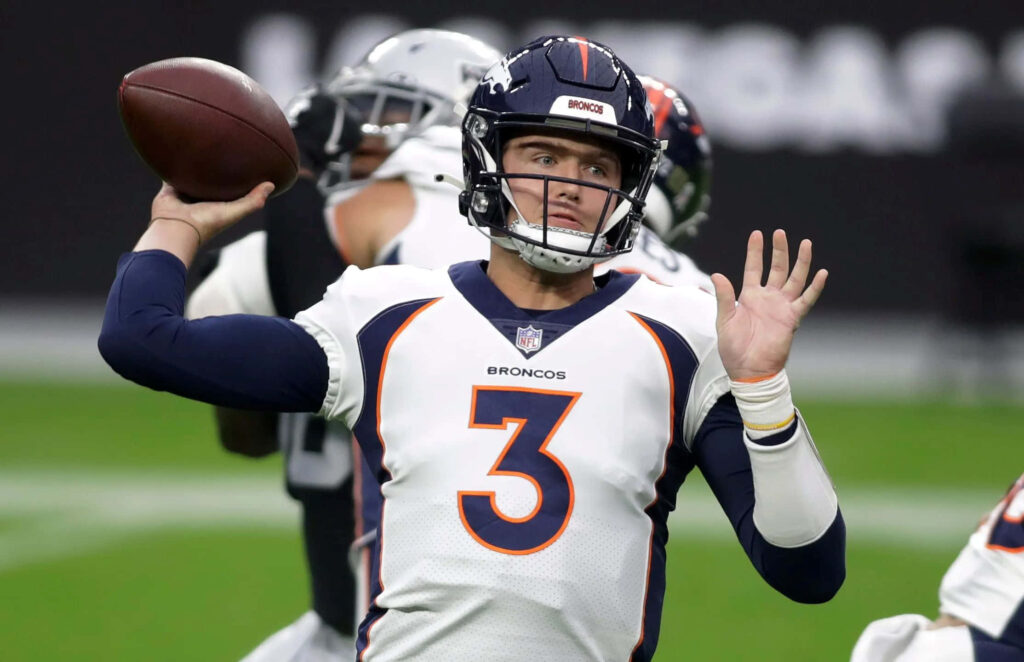 Drew Lock Denver Broncos quarterback mid-throw action dynamic game play orange navy uniform Wallpaper