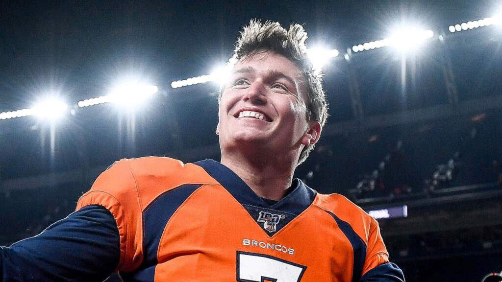 Drew Lock smiling in Broncos uniform with stadium lights background Denver Broncos wallpaper