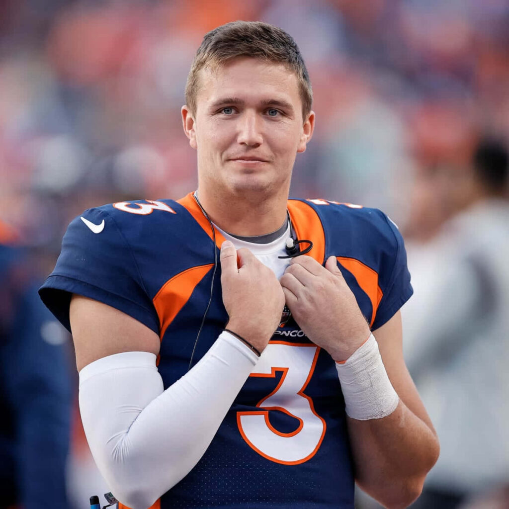 Drew Lock Denver Broncos quarterback in navy orange uniform focused on field high resolution Wallpaper