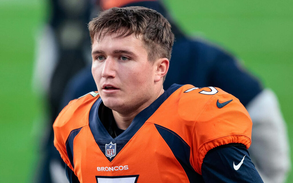 Drew Lock Denver Broncos football player intense action vivid orange blue uniform wallpaper