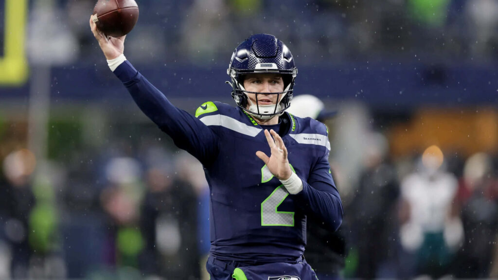 Seattle Seahawks quarterback Drew Lock in dark blue neon green uniform poised to throw football Wallpaper