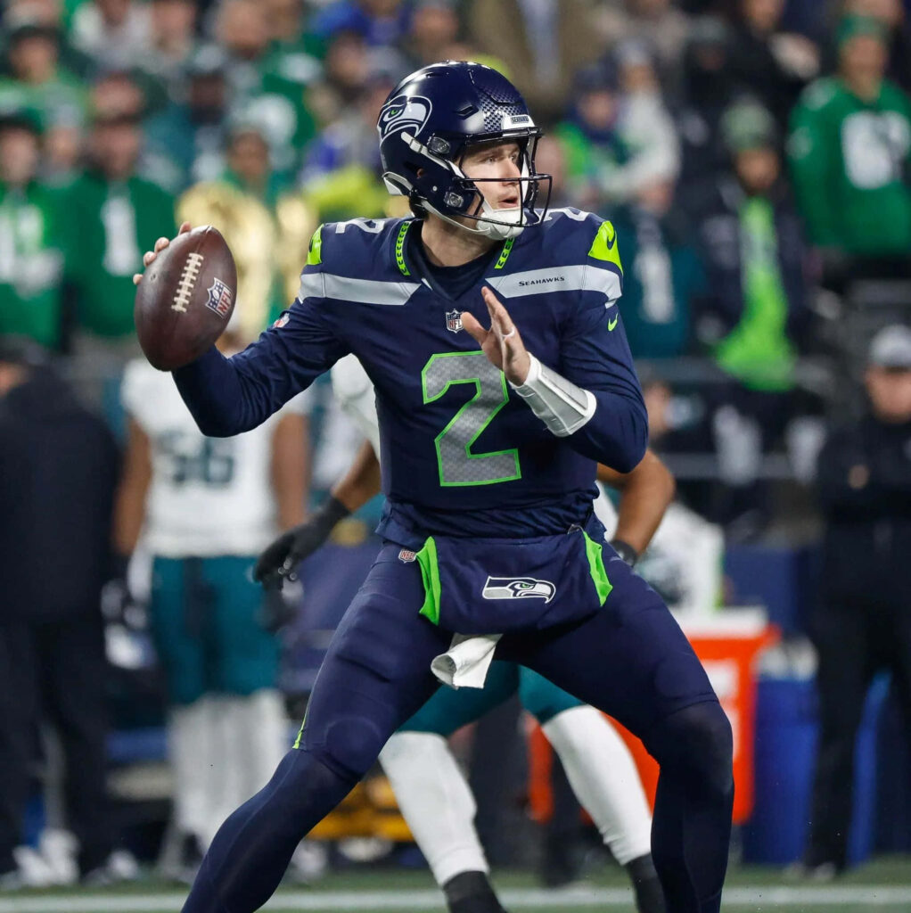 Drew Lock Seattle Seahawks quarterback focused throwing football vibrant stadium wallpaper background