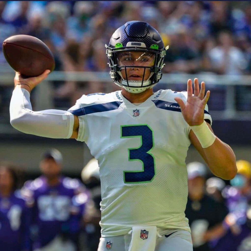 Drew Lock in Seattle Seahawks uniform throwing football mid-action intense quarterback stance Wallpaper