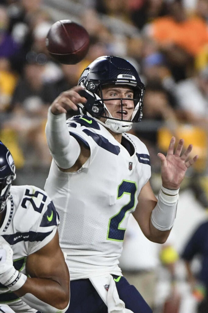Drew Lock Seattle Seahawks quarterback throwing football intense focus stadium background wallpaper