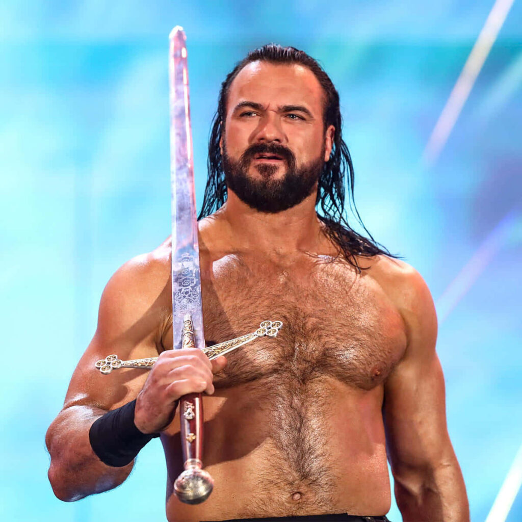 Drew McIntyre holding signature sword with vibrant blue backdrop Scottish wrestler wallpaper
