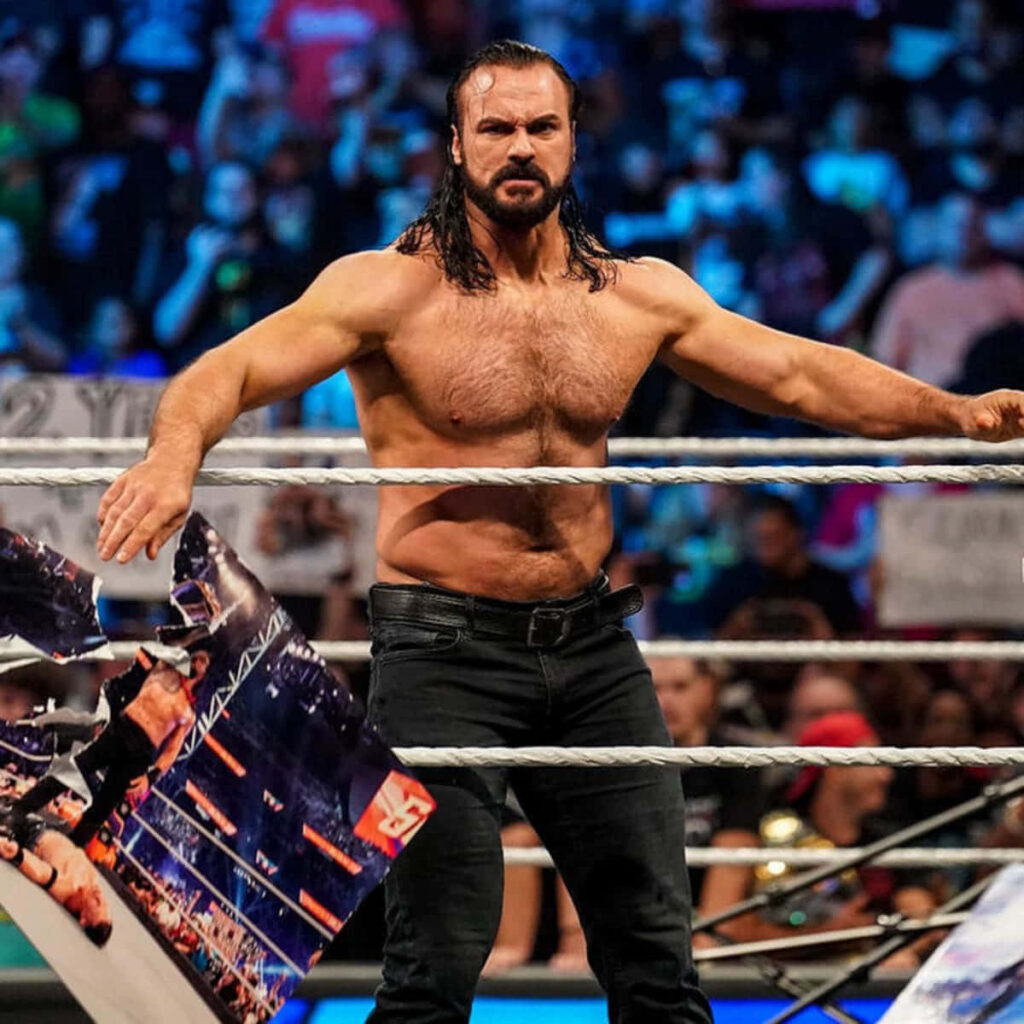 Drew McIntyre fierce Viking wrestler in ring with long hair beard intense expression vibrant arena Wallpaper