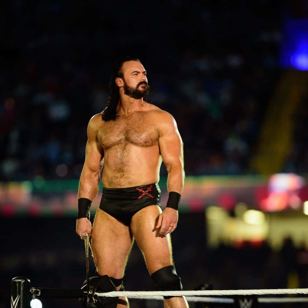 Drew McIntyre in WWE ring with muscular build intense expression vibrant arena lighting wallpaper