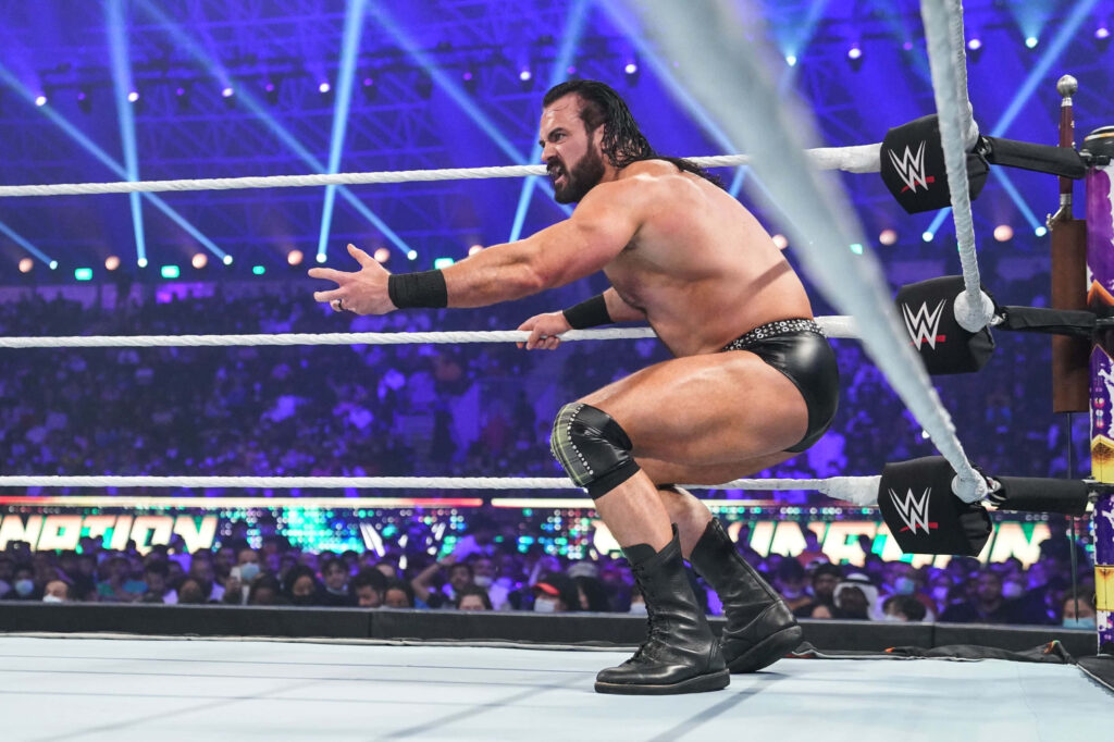 Drew McIntyre powerful WWE wrestler in ring bright arena lights intense dynamic crowd wallpaper