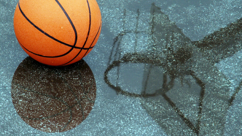 Drenched Hoop: A High-Definition Basketball on Rain-Kissed Ground in Daylight Wallpaper