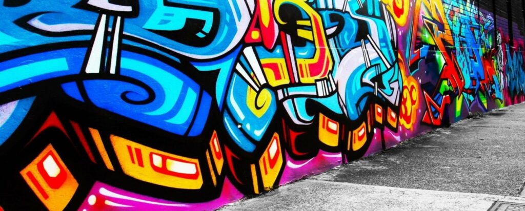 Vibrant abstract graffiti wallpaper with bold street art in electric blues reds and yellows for dual monitors