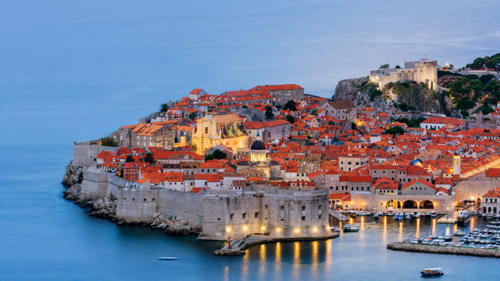 Dubrovnik cityscape at twilight with terracotta rooftops ancient walls and Adriatic Sea view Wallpaper