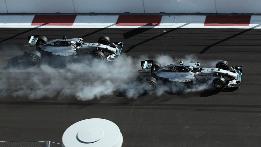 Racing Rivals: Lewis Hamilton and Nico Battle it Out in Two Gray F1 Mercedes AMG Cars - HD Wallpaper for Formula 1 Fans.