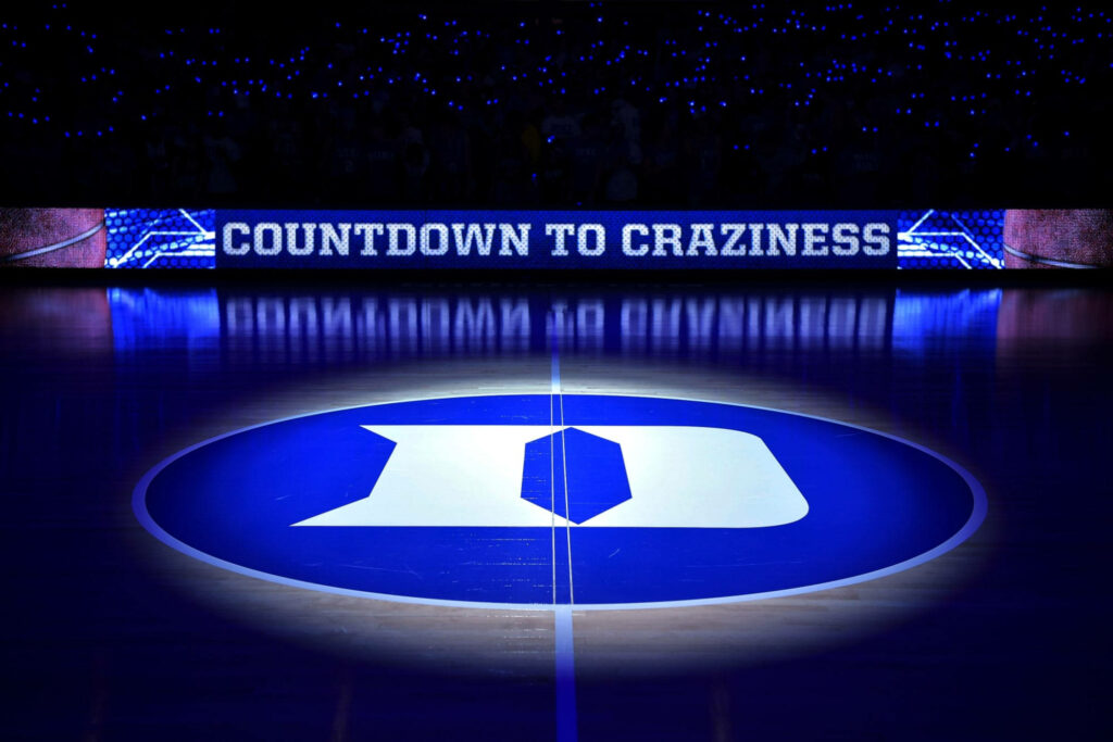 Duke Blue Devils fans energized in glowing blue arena with iconic logo and countdown signage Wallpaper