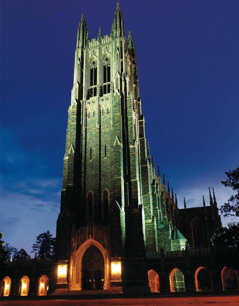 Duke University Chapel Gothic tower glowing at night with warm lights and deep blue sky background Wallpaper