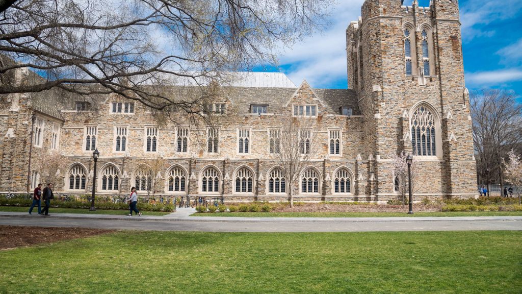 Duke University collegiate Gothic stone building with tower arched windows bright blue sky wallpaper