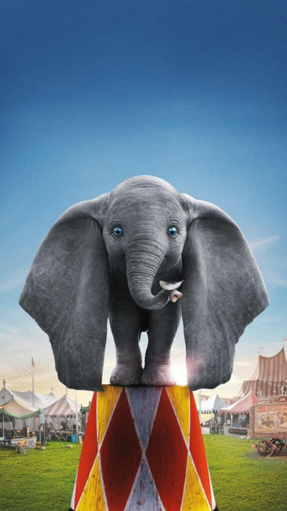 Dumbo on colorful circus pedestal with large ears open wide under bright blue sky wallpaper