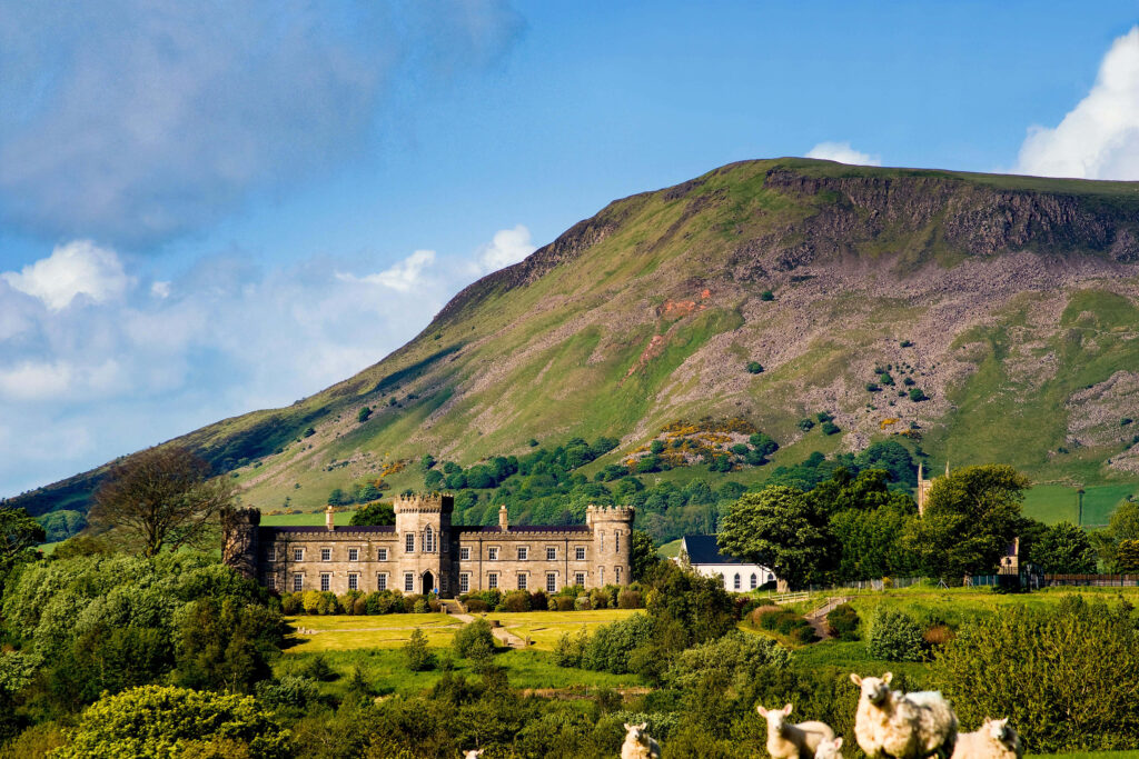 Dungiven Castle in Londonderry surrounded by green hills sheep and vibrant countryside landscape Wallpaper