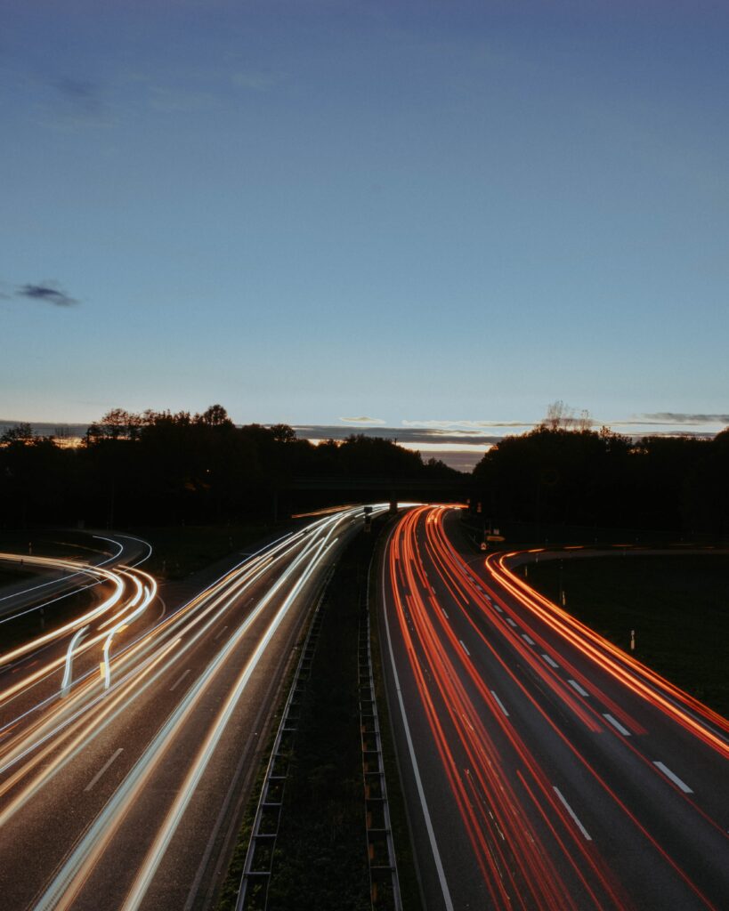 Highway at dusk with long exposure light trails of car headlights and taillights wallpaper background