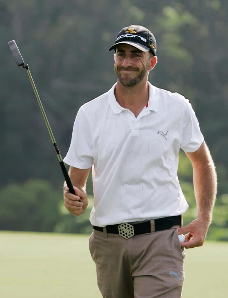 Dustin Johnson smiling golf portrait in white Cobra cap and polo with putter on green course Wallpaper