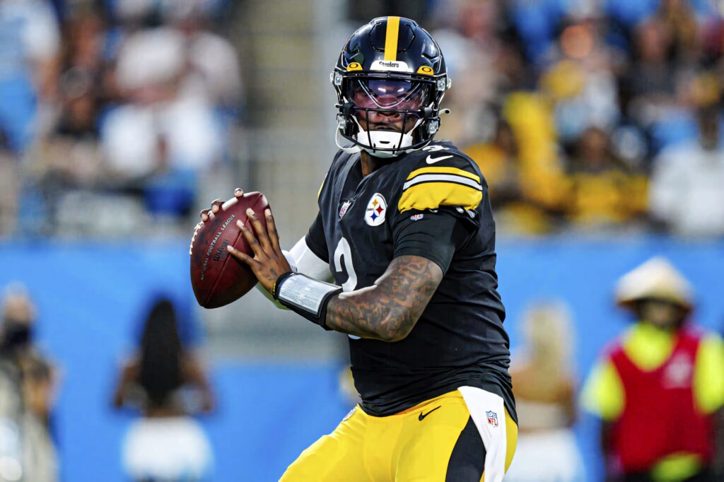 Dwayne Haskins in Pittsburgh Steelers uniform ready to throw football during intense game moment Wallpaper