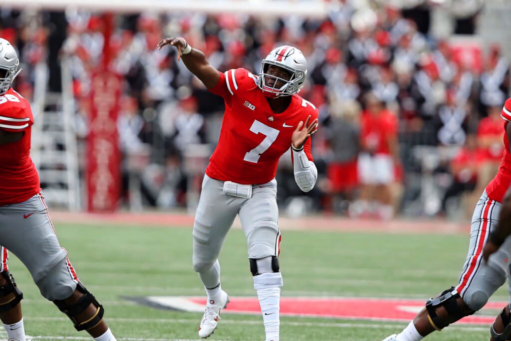 Dwayne Haskins quarterback mid throw in red jersey number 7 football stadium action wallpaper