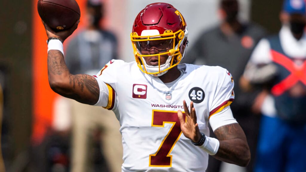 Dwayne Haskins in Washington Football Team uniform poised to throw football with intense focus Wallpaper