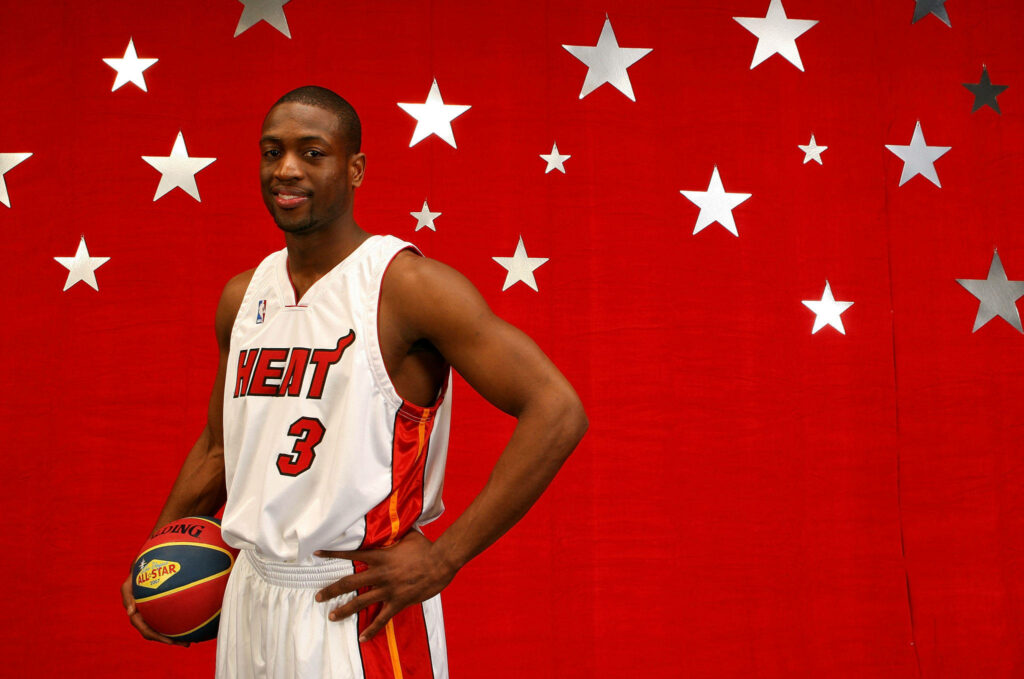 Dwyane Wade in Miami Heat uniform holding basketball against red starry background wallpaper