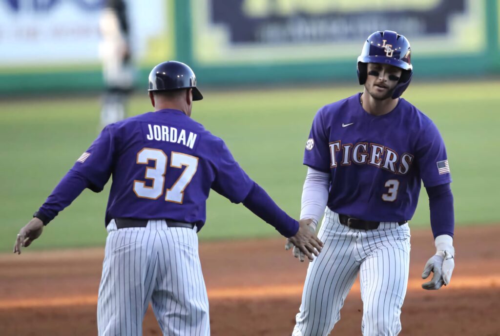 Dylan Crews in purple LSU Tigers uniform high fiving teammate Jordan celebrating baseball win Wallpaper