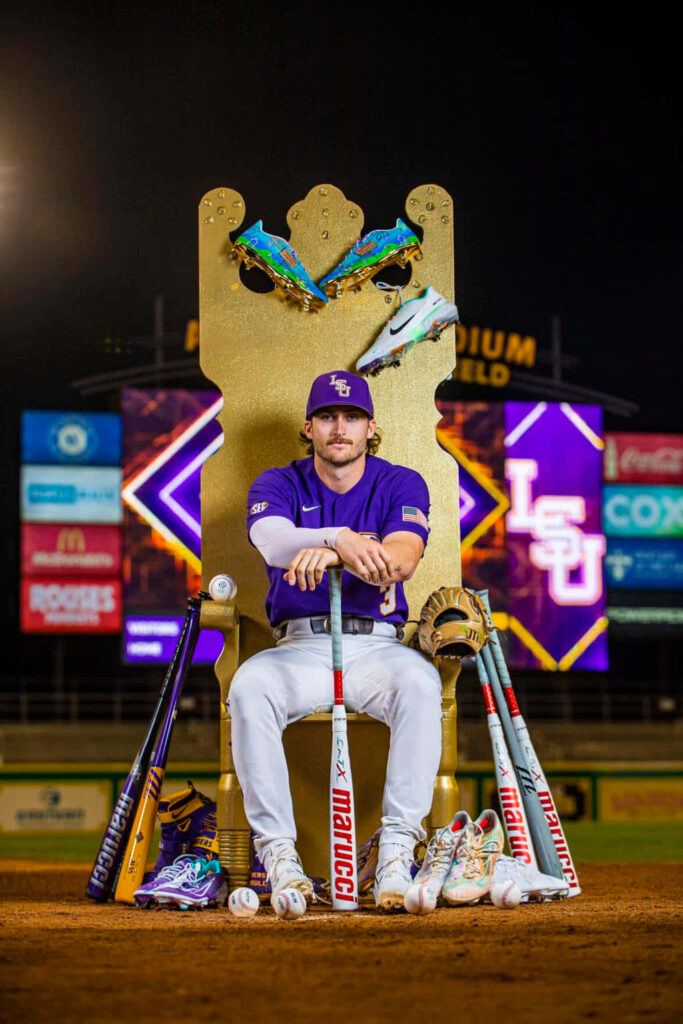 Dylan Crews in LSU uniform on golden throne at baseball stadium with bats balls gloves wallpaper