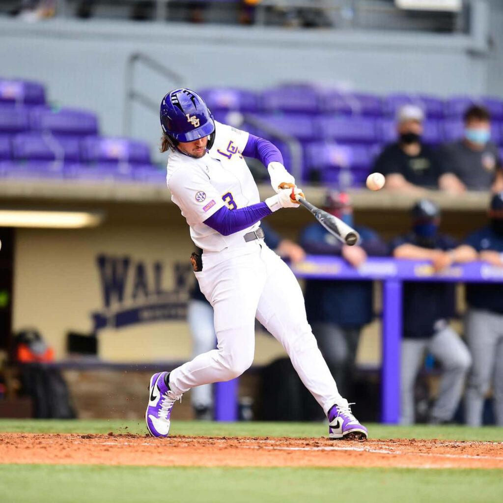 Dylan Crews swinging bat in LSU white purple uniform during dynamic baseball game action Wallpaper