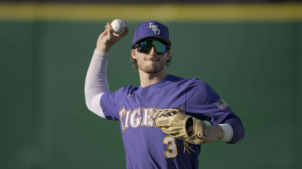 Dylan Crews LSU Baseball purple uniform sunglasses glove warming up focused athletic energy Wallpaper