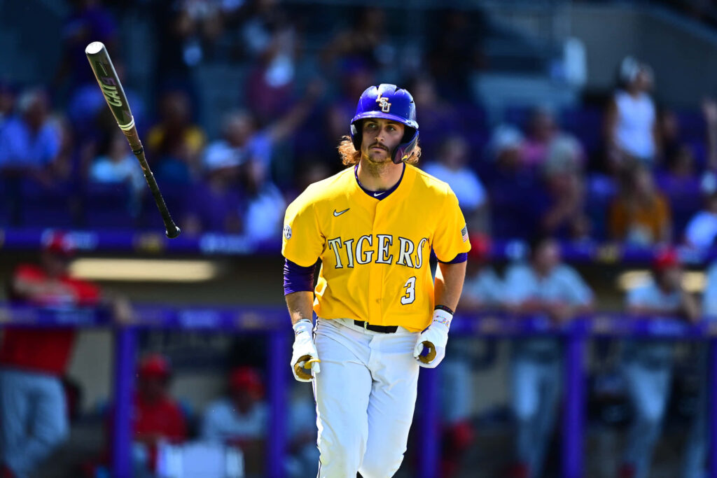 Dylan Crews LSU Tigers mid-bat flip vibrant yellow purple uniform energetic baseball moment Wallpaper