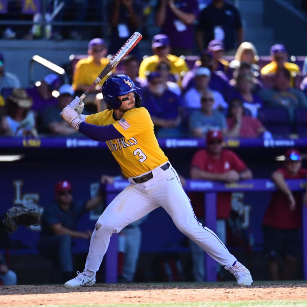 Dylan Crews mid-swing in LSU Tigers uniform vibrant baseball action with crowd and stadium background Wallpaper