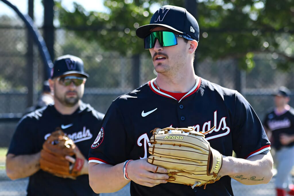Dylan Crews in navy Nationals uniform with sunglasses and tan Wilson glove during baseball practice Wallpaper