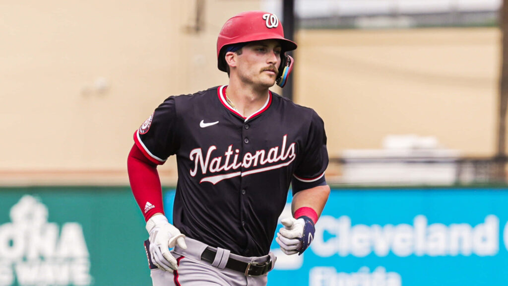 Dylan Crews in Washington Nationals uniform in dynamic pose with bold red black stadium background Wallpaper
