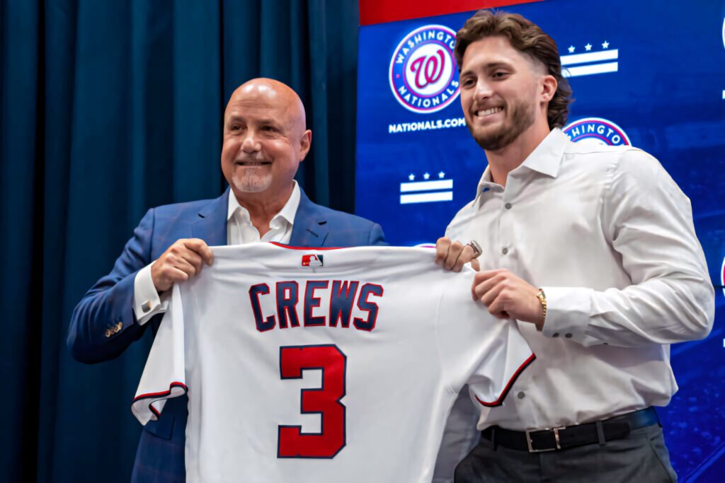 Dylan Crews and team executive smile presenting number 3 Washington Nationals jersey reveal background Wallpaper