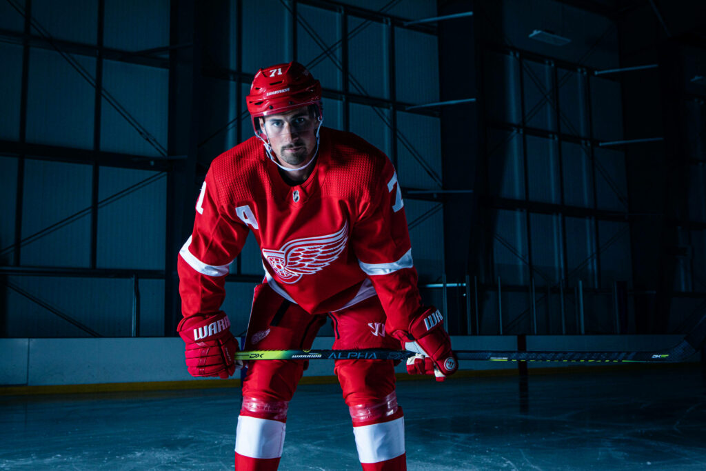Dylan Larkin Detroit Red Wings ice hockey player in action on icy arena background wallpaper
