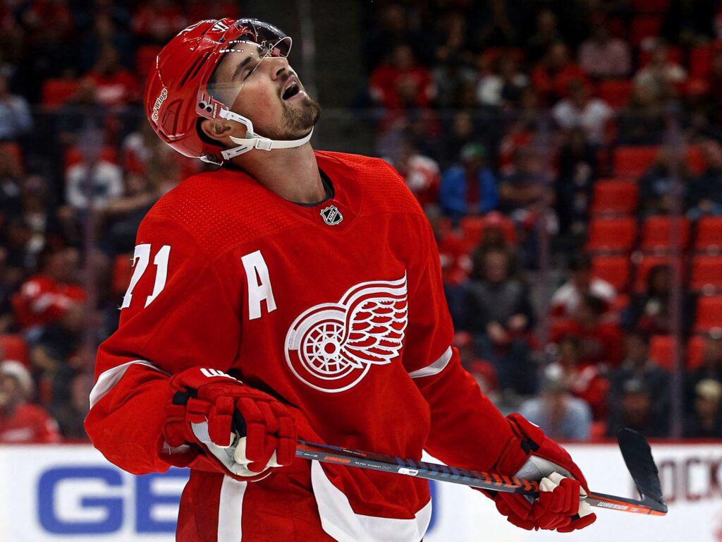 Red Wings center Dylan Larkin in action wearing red white jersey with winged wheel logo wallpaper
